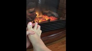Wife taking Socks off Playing with her Feet by the Fire